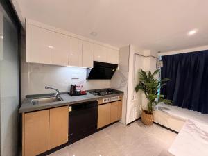 a small kitchen with a sink and a stove at Livetour Hotel HaiZhu Hopson New Plaza Guangzhou in Guangzhou