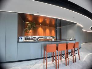 een bar met oranje stoelen in een kamer bij Livetour Hotel HaiZhu Hopson New Plaza Guangzhou in Guangzhou