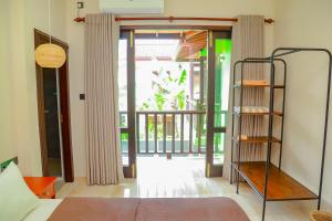 Schlafzimmer mit einem Bett und einer Tür zu einem Balkon in der Unterkunft IBSON Villa - 02 Hikkaduwa with 4 Bedrooms & Salt Water Swimming Pool in Hikkaduwa