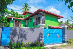 a colorful house with a fence at IBSON Villa - 02 Hikkaduwa with 4 Bedrooms & Salt Water Swimming Pool in Hikkaduwa