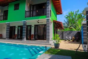 a house with a swimming pool in front of it at IBSON Villa - 02 Hikkaduwa with 4 Bedrooms & Salt Water Swimming Pool in Hikkaduwa