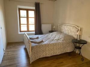 a bedroom with a bed with two tables and a window at Auberge de Corsas in Saint-Victor