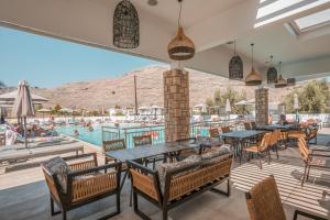 een patio met tafels en stoelen en een zwembad bij Lambis Studios & Apartments in Lindos