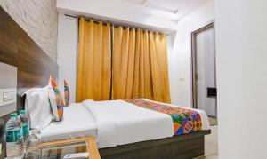 a bedroom with a large bed and a window at FabHotel Shyam in Zirakpur