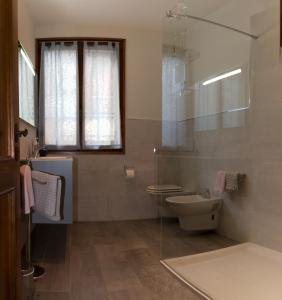 Casinalbo的住宿－26 Bed and Breakfast，一间带卫生间和玻璃淋浴间的浴室