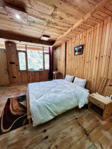1 dormitorio con 1 cama en una cabaña de madera en Golden heritage dharali en Harsil