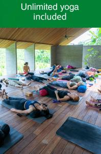 a large group of people doing yoga in a room at Ubuntu Bali Eco Yoga Retreat - CANGGU in Canggu