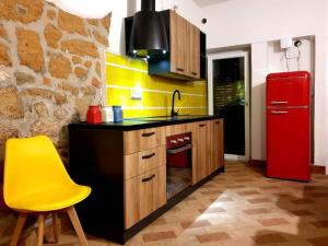 una cucina con un frigorifero rosso e una sedia gialla di Casa Mattia Centro Storico a Cisterna di Latina