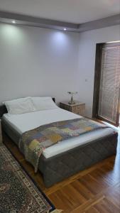 - une chambre avec un grand lit et un tapis dans l'établissement Apartman Anna, à Kragujevac