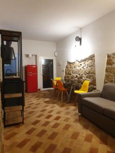 sala de estar con sofá, sillas y pared de piedra en Casa Mattia Centro Storico, en Cisterna di Latina