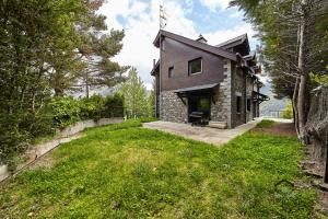 a house on a hill with a green yard at Chalet el Salze in La Massana