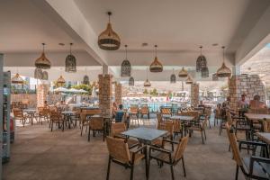 een restaurant met tafels en stoelen en mensen aan tafel bij Lambis Studios & Apartments in Lindos