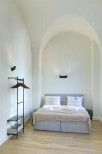 a bedroom with a bed with a white wall at vonBehling Boutique Apt. - Historisch und modern in Wiesbaden