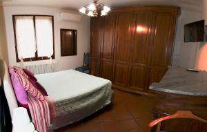 1 dormitorio con 1 cama y armario de madera en 26 Bed and Breakfast en Casinalbo