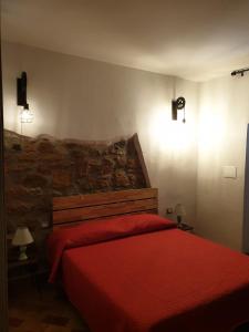 1 dormitorio con 1 cama roja y 2 lámparas en Casa Mattia Centro Storico, en Cisterna di Latina