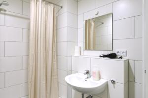 a white bathroom with a sink and a mirror at vonBehling Boutique Apt. - Historisch und modern in Wiesbaden