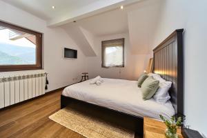 a bedroom with a large bed and a window at Chalet el Salze 10 pax in La Massana