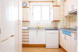 a kitchen with white cabinets and a sink and a window at GuestReady - Vintage Elegance in Catalonia in Cornellà de Llobregat