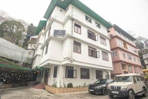 a white building with cars parked in front of it at Magpie Mall Road Residency (MG Marg) in Gangtok
