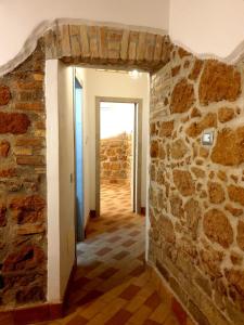 pasillo con pared de piedra y puerta en Casa Mattia Centro Storico, en Cisterna di Latina