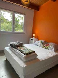 1 dormitorio con 1 cama grande y pared de color naranja en Maison, 150 m de la plage, la Tresson,Noirmoutier, en La Guérinière