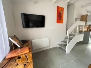 sala de estar con escalera y TV de pantalla plana en Maison, 150 m de la plage, la Tresson,Noirmoutier, en La Guérinière