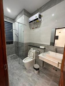 La salle de bains est pourvue de toilettes, d'un lavabo et d'une douche. dans l'établissement 1994 House, à Da Thanh
