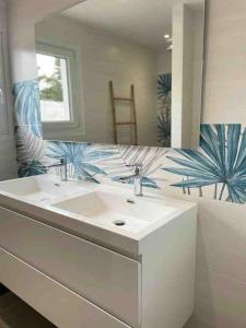 y baño con lavabo blanco y espejo. en Maison, 150 m de la plage, la Tresson,Noirmoutier, en La Guérinière