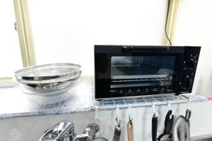 a microwave oven sitting on top of a kitchen counter at JH Yellow Guest House in Tokyo