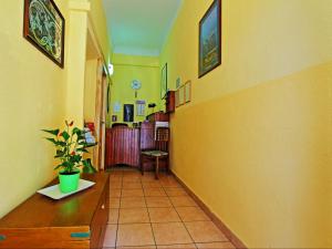 a hallway with yellow walls and a table with a potted plant at Innpiero in Taormina