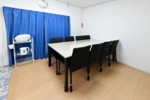 a dining room with a table and black chairs at JH Yellow Guest House in Tokyo