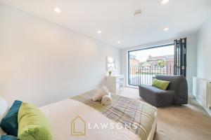 a bedroom with a bed and a couch and a window at Watt a Stay I Free EV Parking in Windsor