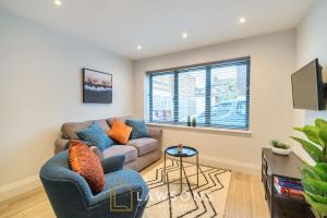 ein Wohnzimmer mit einem Sofa und einem TV in der Unterkunft Chic Living by Lawsons in Windsor