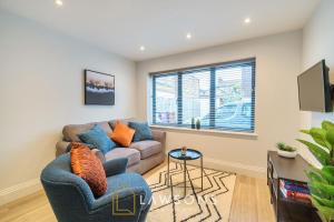 a living room with a couch and a tv at Watt a Stay I Free EV Parking in Windsor