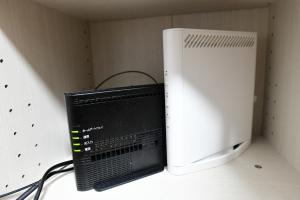 a computer monitor sitting next to a microwave at JH Yellow Guest House in Tokyo