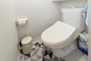a bathroom with a white toilet and a trash can at JH Yellow Guest House in Tokyo