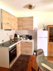 a kitchen with wooden cabinets and a white refrigerator at Cima de' Piazzi Apartment 2 in Isolaccia