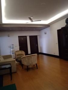 uma sala de estar com um sofá e cadeiras e um tecto em Tavisha Villa Flim City Road Dadri Road em Noida