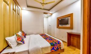 a bedroom with a bed and a flat screen tv at FabExpress Clock View in Mussoorie