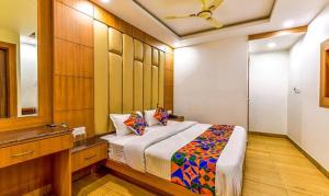 una camera da letto con un letto grande e uno specchio di FabExpress Clock View 500M From The Mall Road a Mussoorie