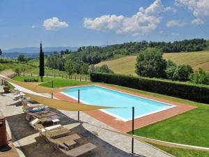 ein großer Pool in einem Garten mit Stühlen in der Unterkunft Agriturismo Le Buche di Viesca in Reggello