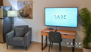 a room with a desk with a tv and a chair at Rare Holiday Homes - Close to Stadium - Canal View - Stadium Point - R811 - Dubai Sports City in Dubai