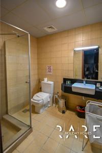 a bathroom with a toilet and a sink and a shower at Rare Holiday Homes - Close to Stadium - Canal View - Stadium Point - R811 - Dubai Sports City in Dubai