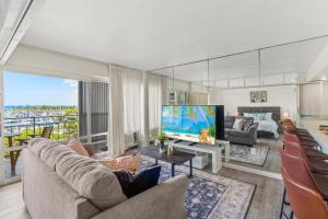 sala de estar con TV grande y sofá en Ilikai Hotel with Ocean View en Honolulu