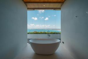 a bath tub in a bathroom with a large window at Beyond The Sea - Luxe Sea View Villa in Jimbaran in Jimbaran