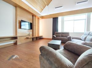 a living room with two couches and a flat screen tv at Bay Resort Penthouse by Evernent in Miri