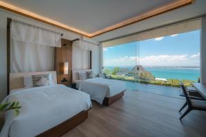 a bedroom with two beds and a view of the ocean at Beyond The Sea - Luxe Sea View Villa in Jimbaran in Jimbaran