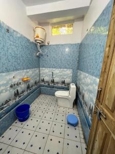 Baño azul con aseo y lavamanos en Golden heritage dharali en Harsil