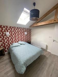een slaapkamer met een bed en een dakraam bij Gîte Le Ballandeau in Ballan-Miré