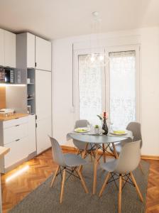 uma cozinha e sala de jantar com mesa e cadeiras em Dorotea Lux em Belgrado